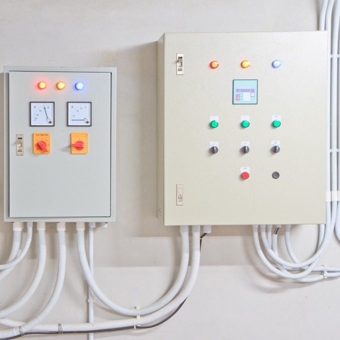 Two white electrical panels are pictures together; they are white and painted against a white background.