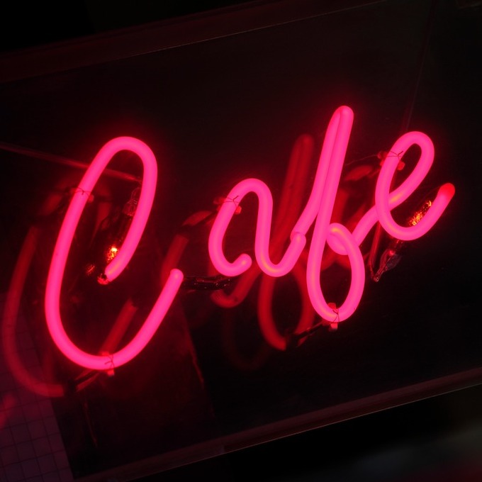 A neon sign that says, "Cafe" set against a black background.